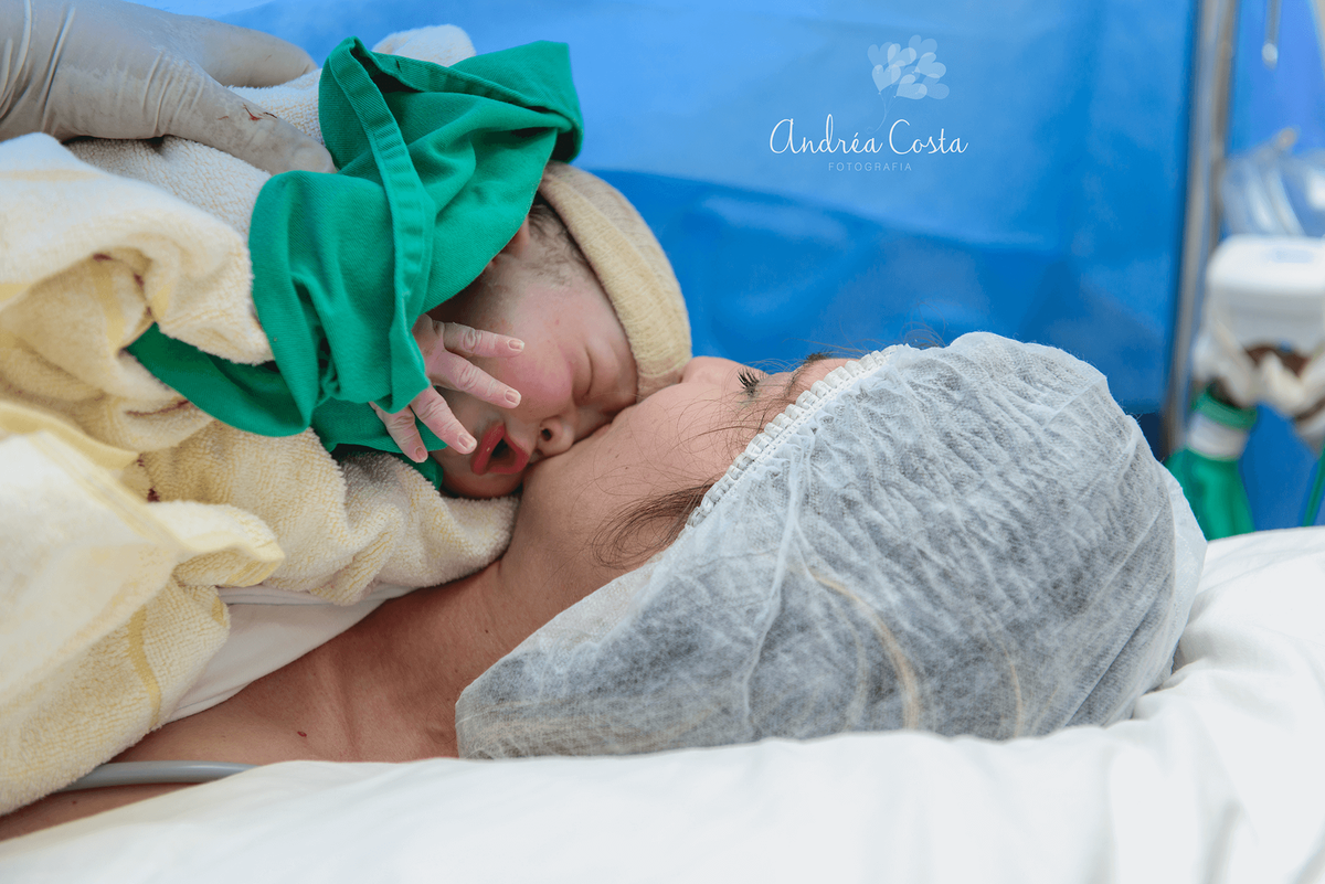 Mamãe beijando o filho recém nascido, por Andréa Costa