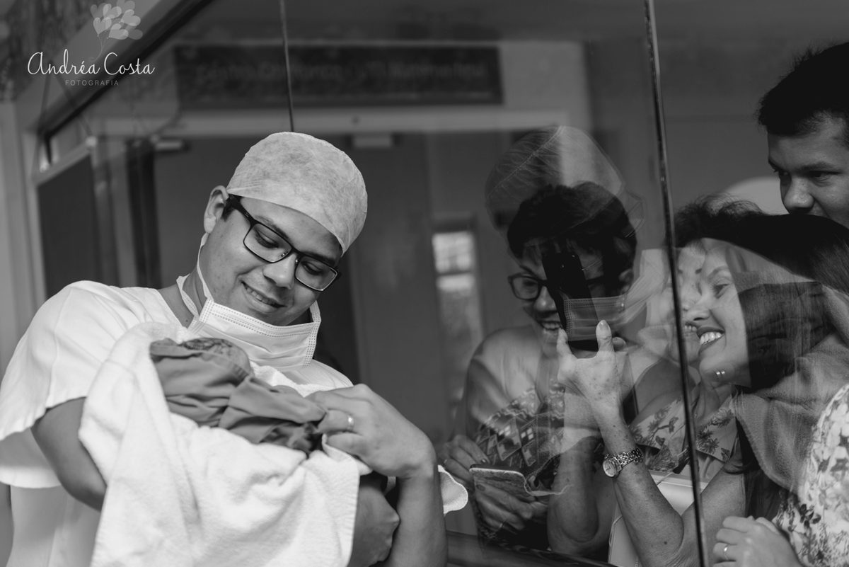 Papai mostrando seu filho recém nascido no vidro do berçario da Perinatal da Barra da Tijuca, RJ, por Andréa Costa