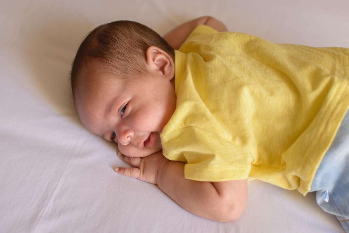 bebê em cima da cama em ensaio em casa, por Andréa Costa