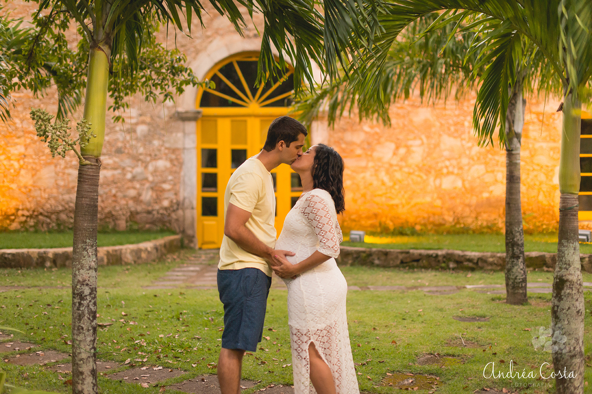 Casal se beijando com as mãos na barriga à espera do Matheus, por Andréa Costa