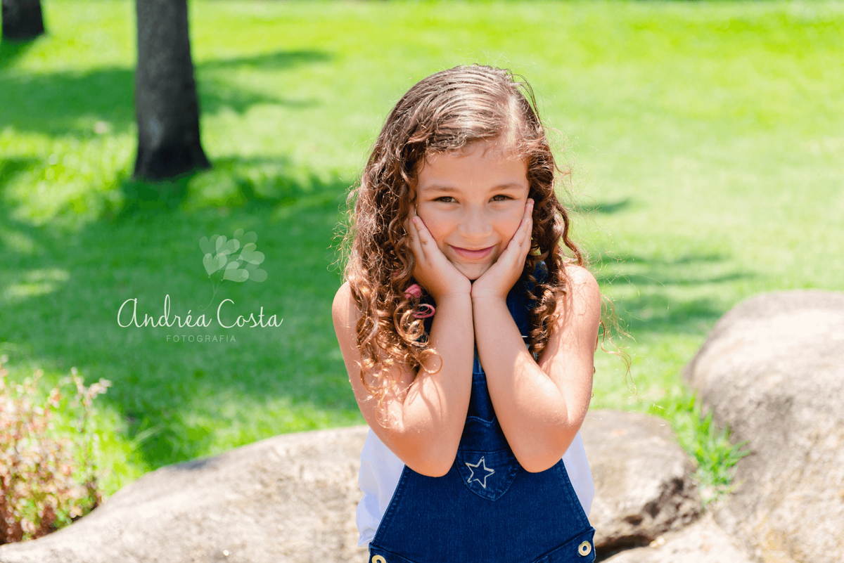 mila com as mãos no rosto fazendo charme para foto em ensaio familia realizado no Rio de Janeiro, por Andréa Costa