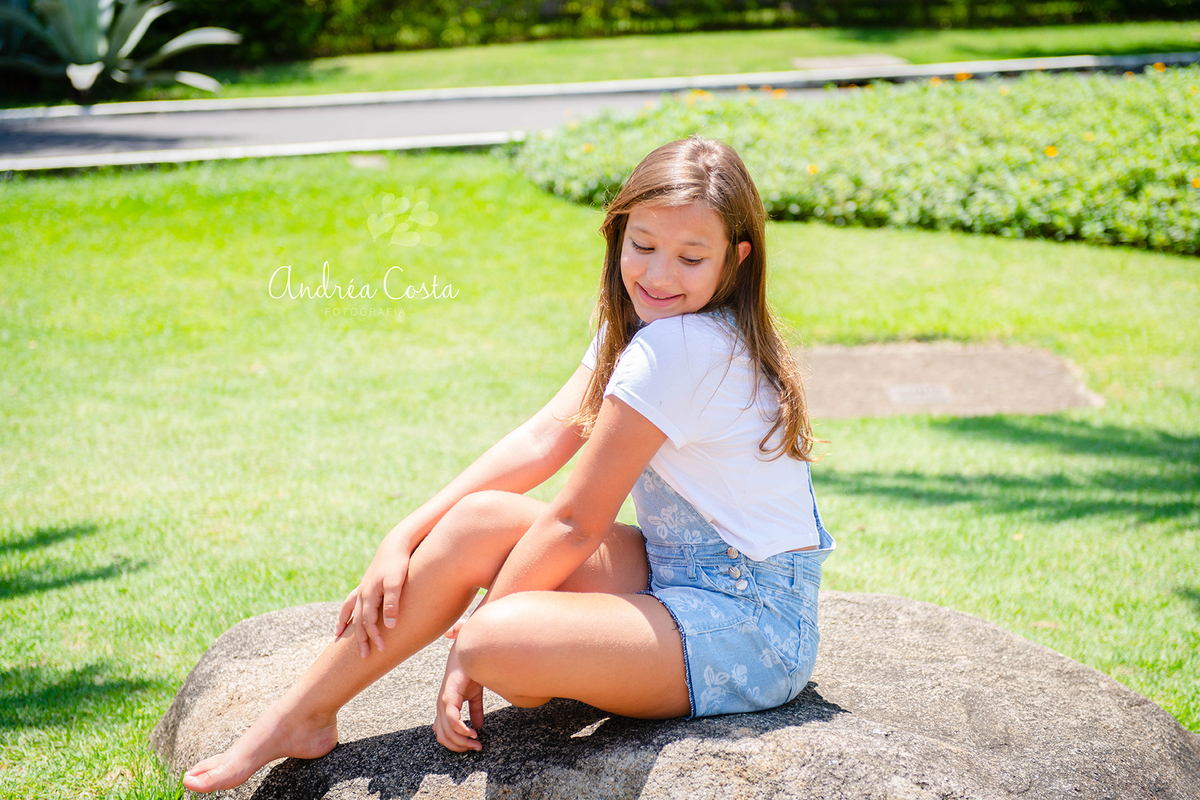 manu sentada na pedra em lindo jardim localizado na Barra da Tijuca, por Andréa Costa