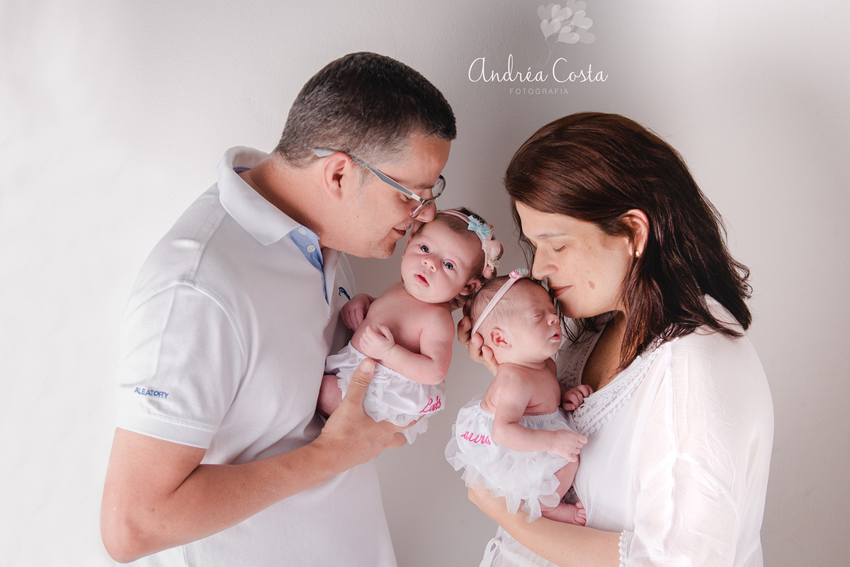 foto dos pais com as filhas recém nascidas em ensaio newborn feito em casa no rio de janeiro, por Andréa Costa