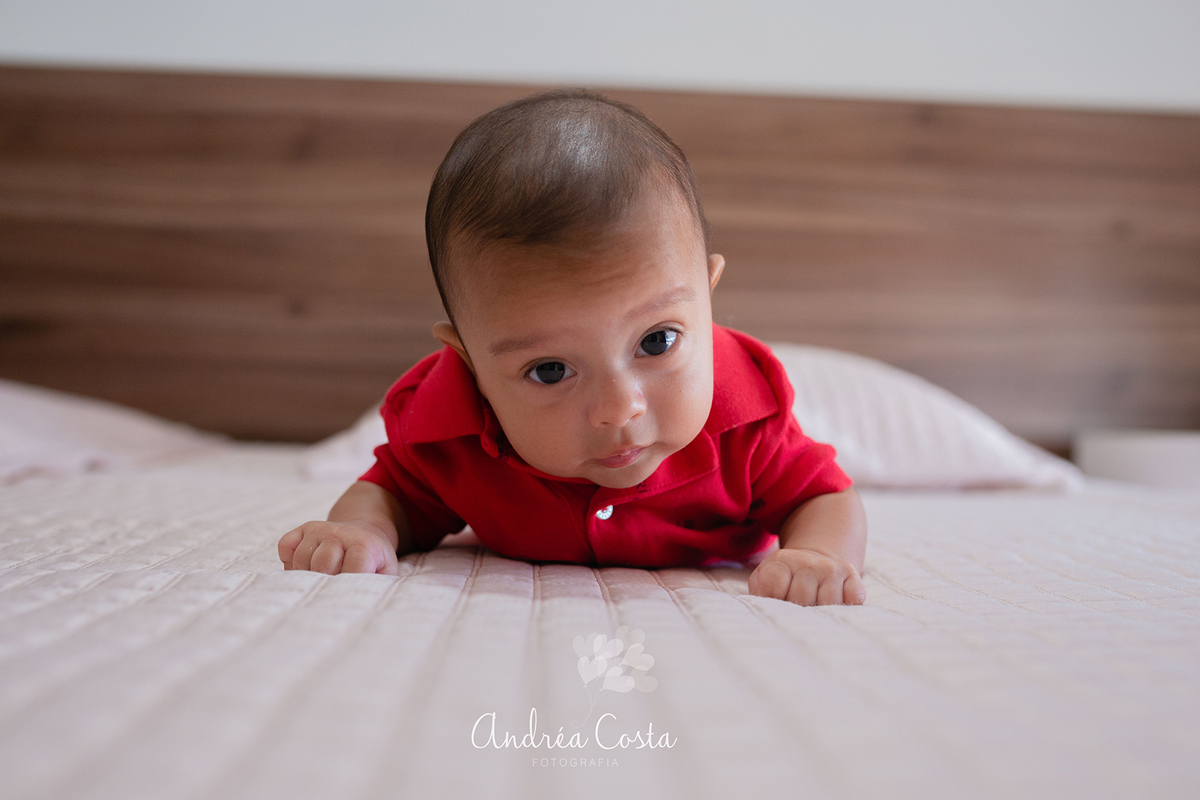 Enriko deitado de bruços na cama do pais em ensaio Life Style