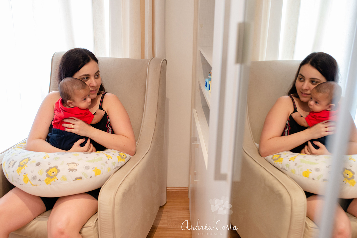 Mãe e filho olhando o reflexo no espelho sentados no quarto do bebê