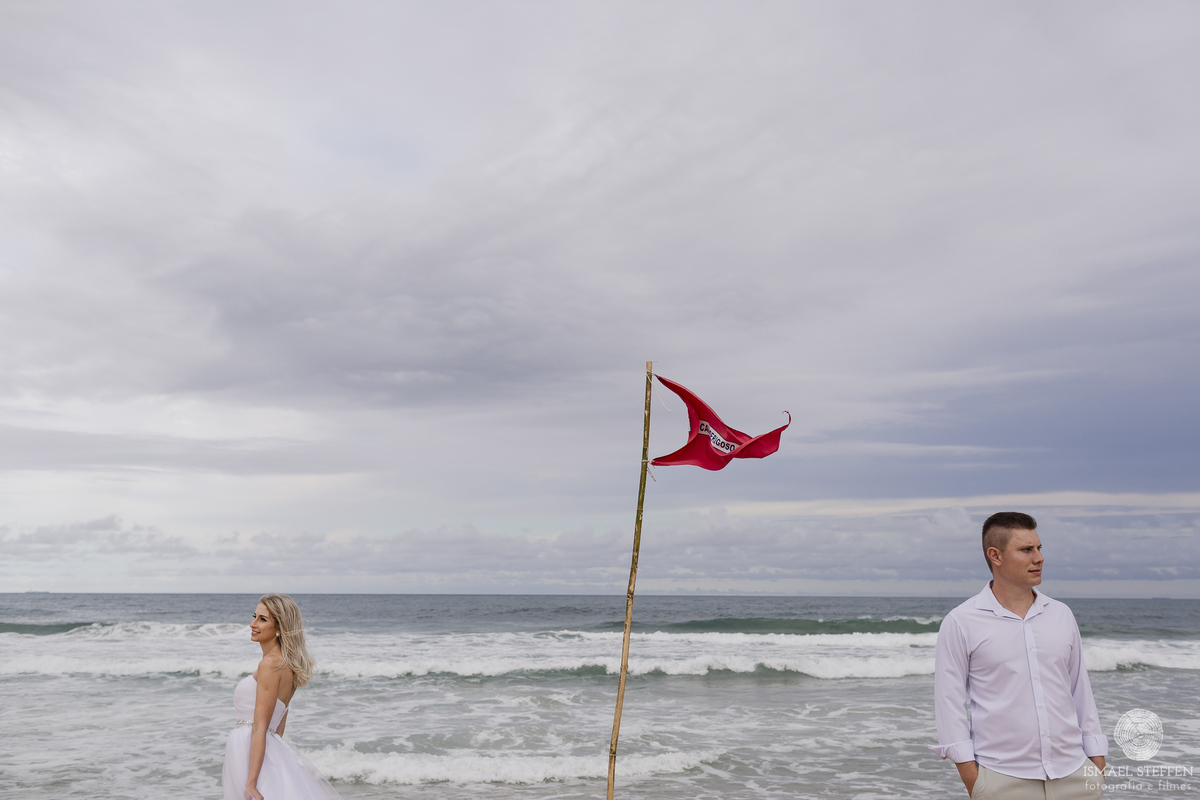 casal separado pela bandeira na praia