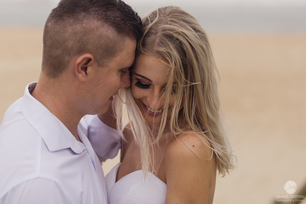 casal abraçado na beira da praia do silveira