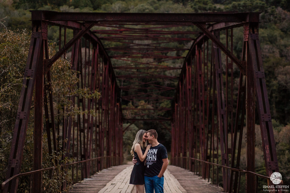 casal juntinhos em ponte de ferro