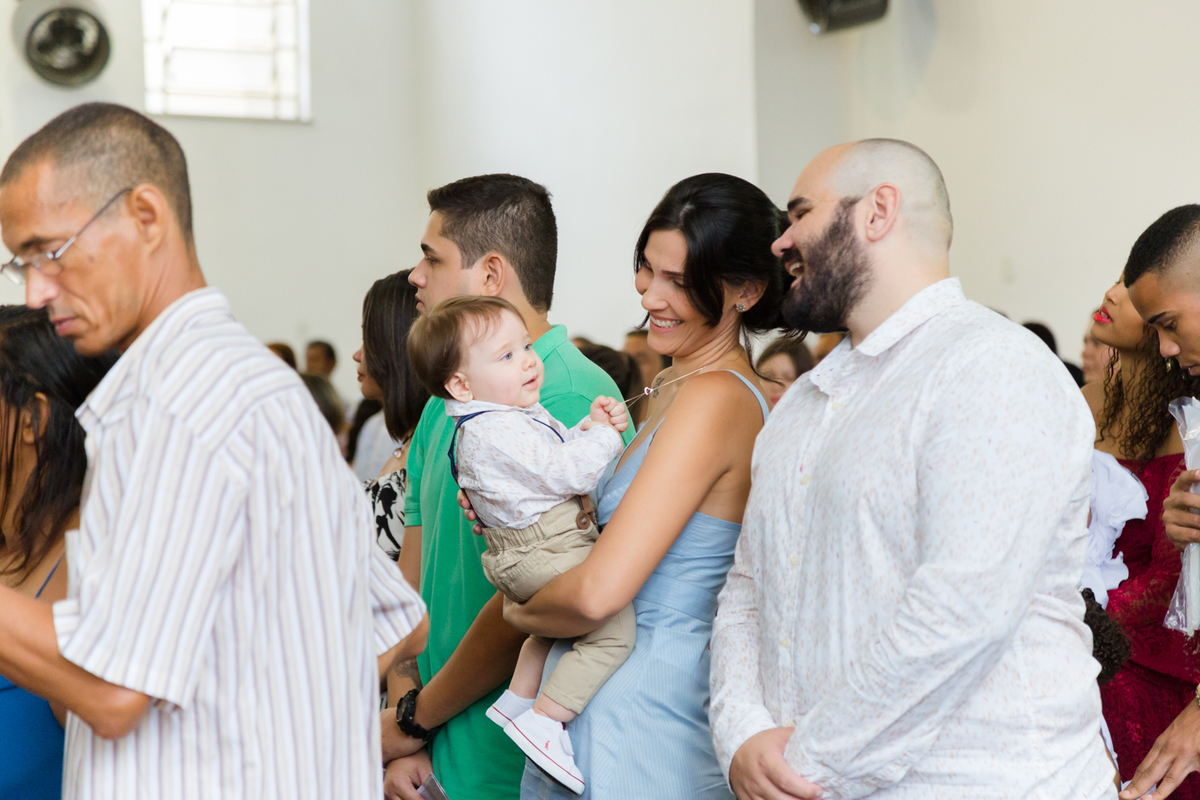 Pais brincam com filho durante a cerimônia de batizado