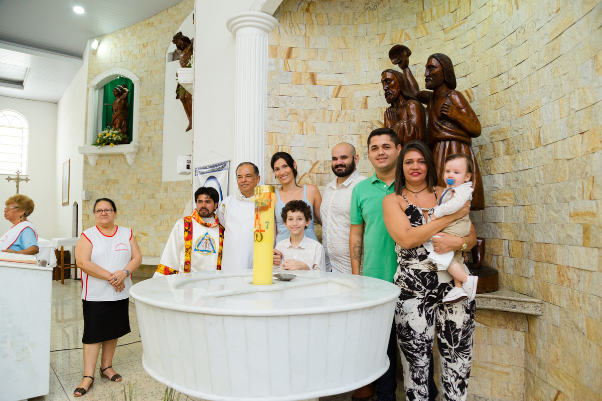 Família posa para foto na pia batismal da igreja