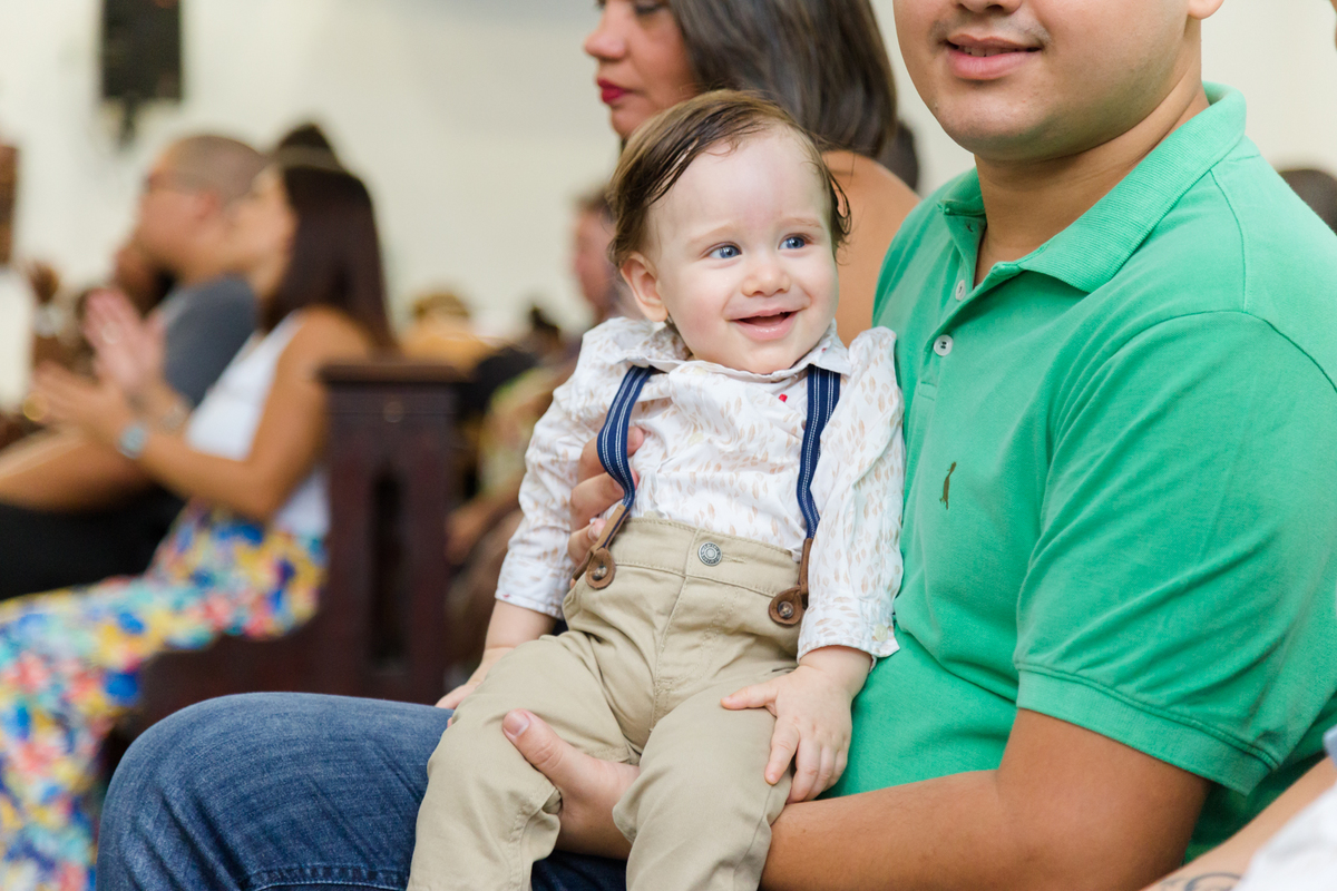 Criança sorri para foto na cerimônia de batismo
