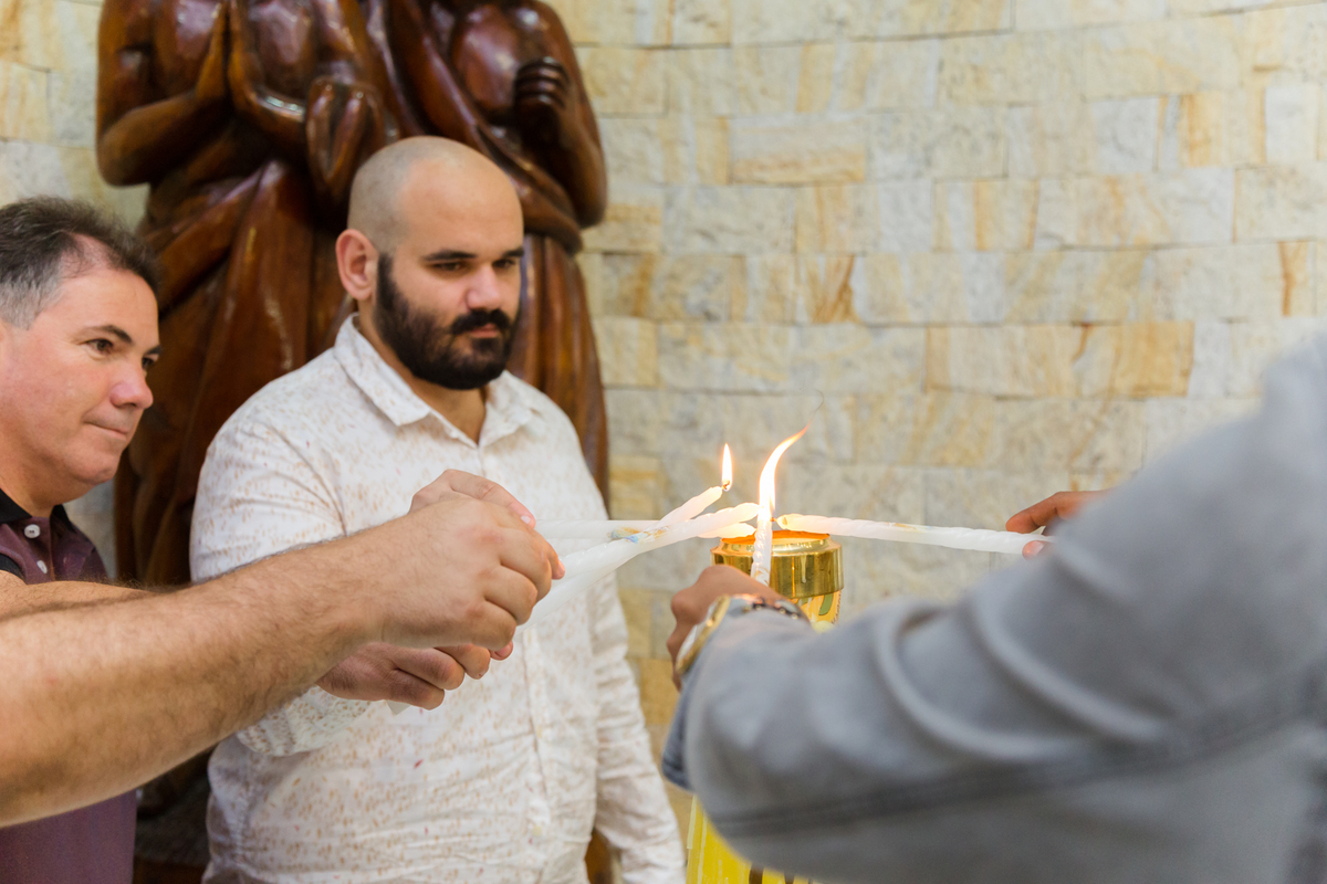 Padrinhos acendendo a vela de batismo