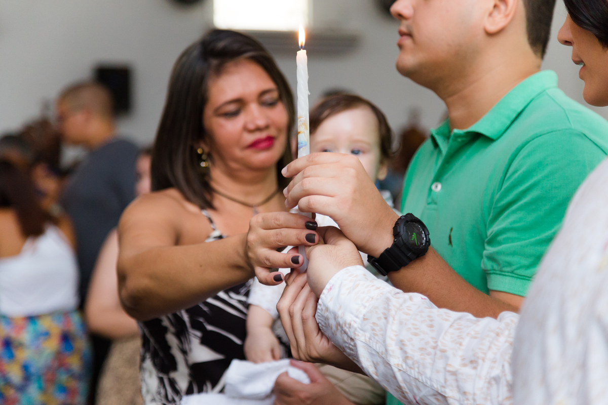 Padrinhos seguram a vela do batizado