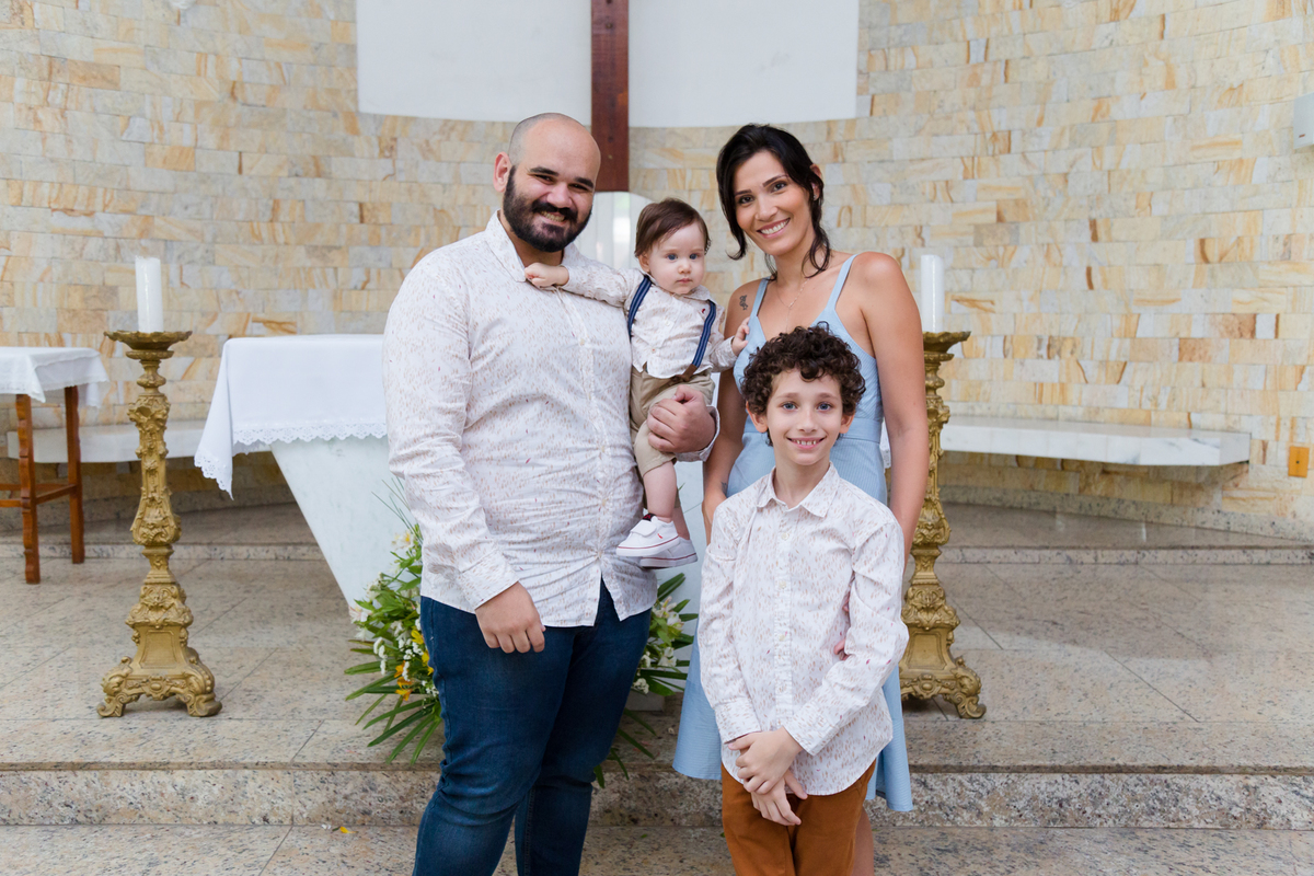 Família posa para foto na igreja após o batizado do filho