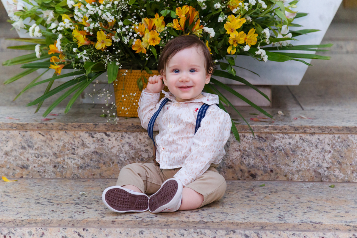 Criança faz pose no altar para foto após o batizado