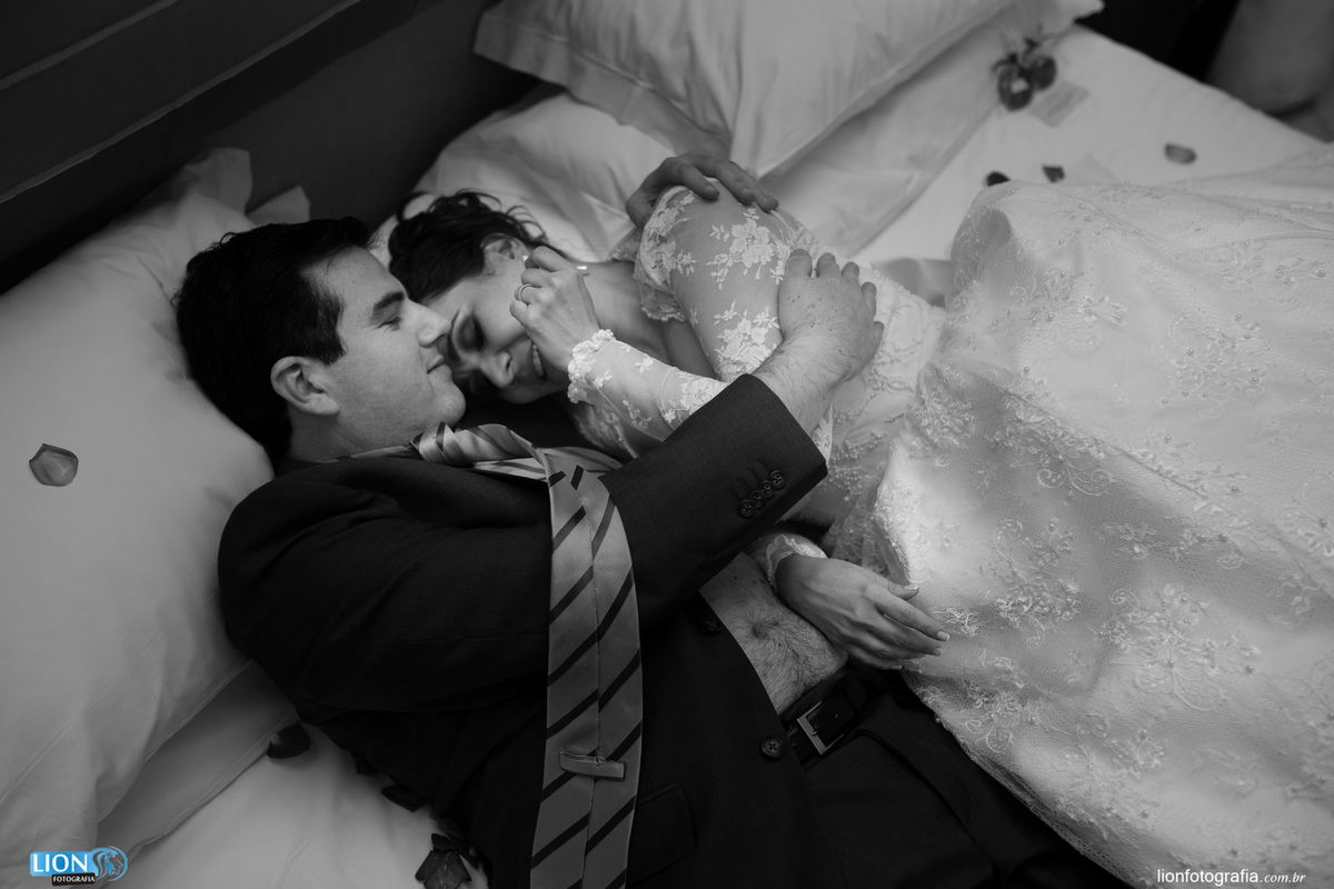 Casal apaixonado deitados no quarto de hotel após o casamento