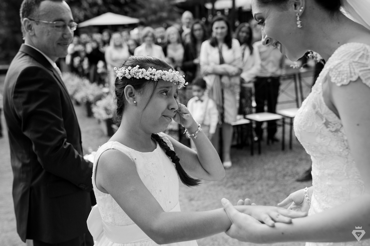 daminha emocionada segura a mão da noiva