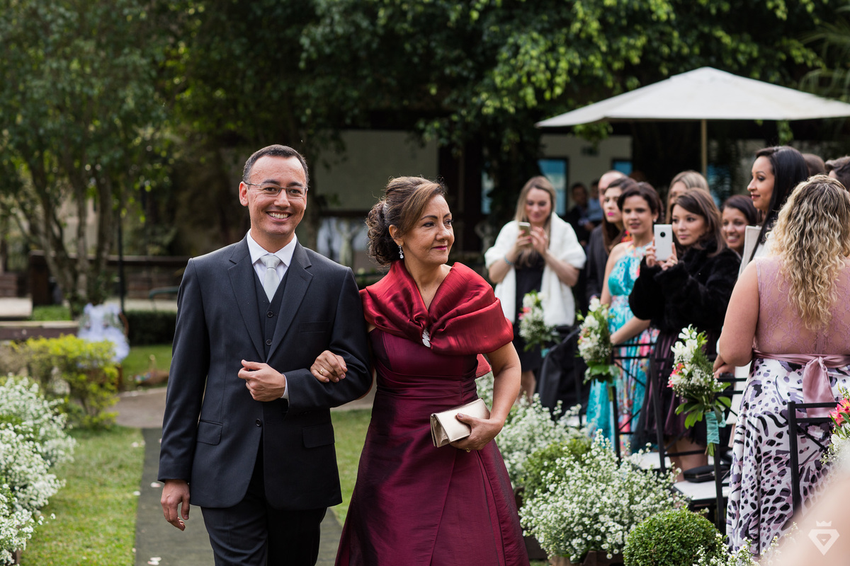 noivo entra com sua mãe no casamento no campo