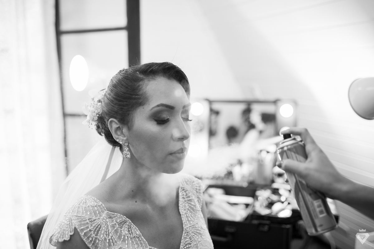 noiva passando spray para proteger a maquiagem