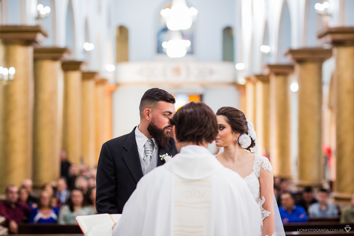 noivos trocam olhares durante a cerimonia na igreja