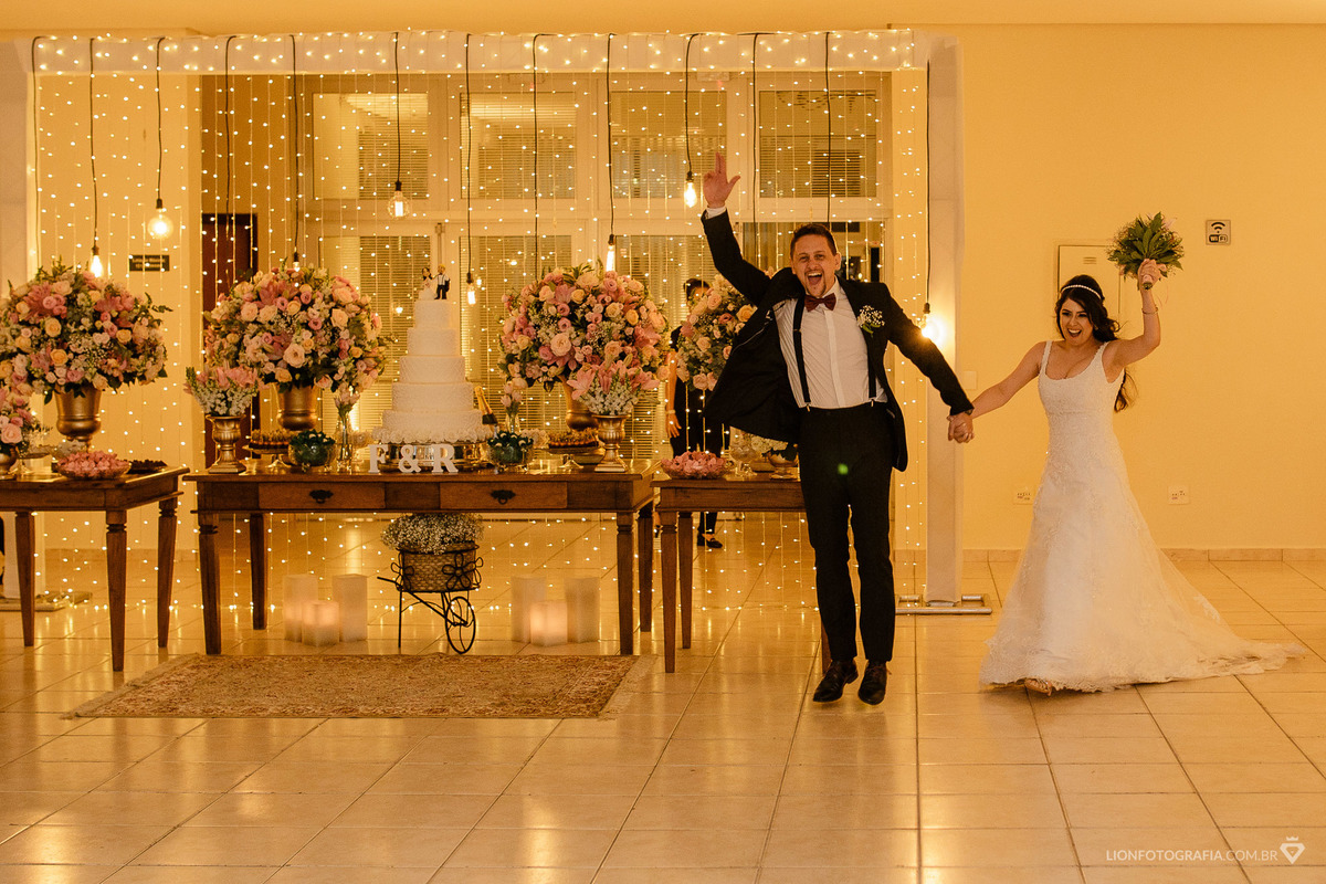 noivos entram na festa muito felizes e empolgados, pulando e cantando