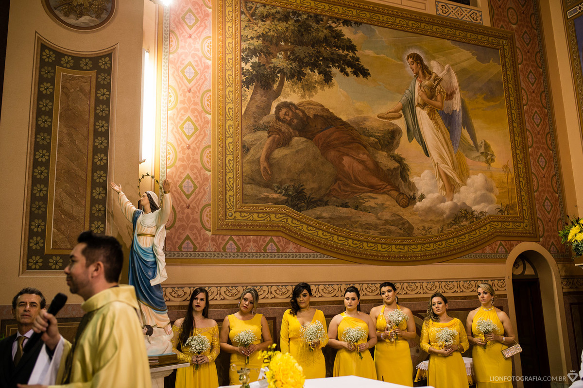 todas madrinhas do casamentos estavam combinando seus vestidos amarelos no mesmo tom da decoração da igreja
