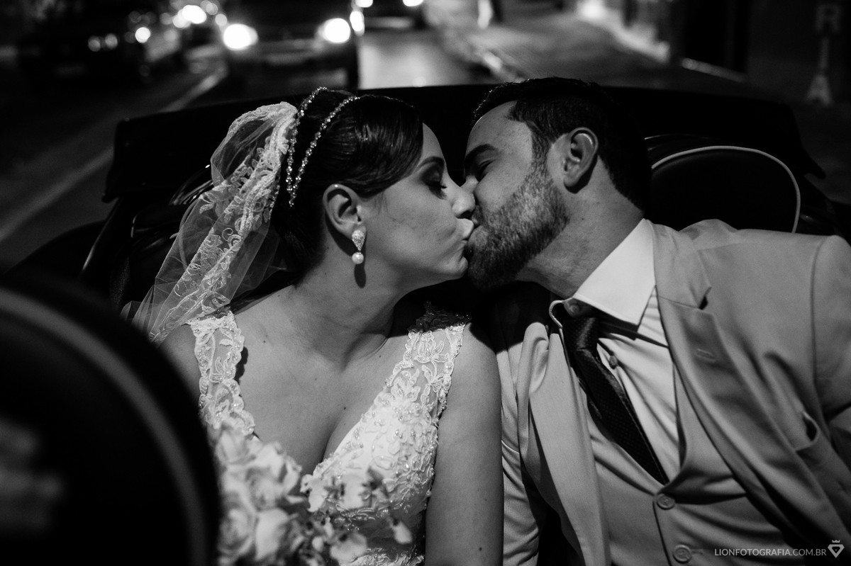 o casal se beijando no carro a caminho da  festa
