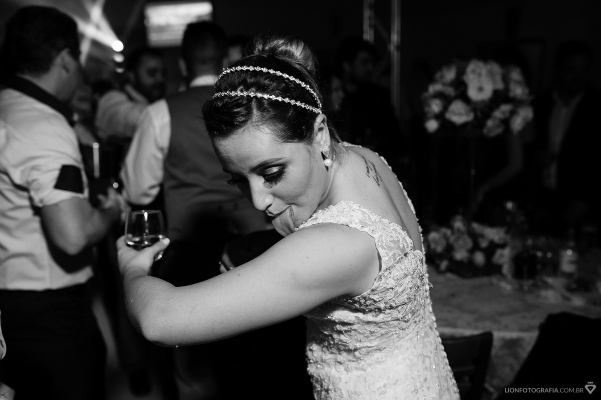 noiva lambendo seu próprio braço em um momento inusitado da festa de casamento