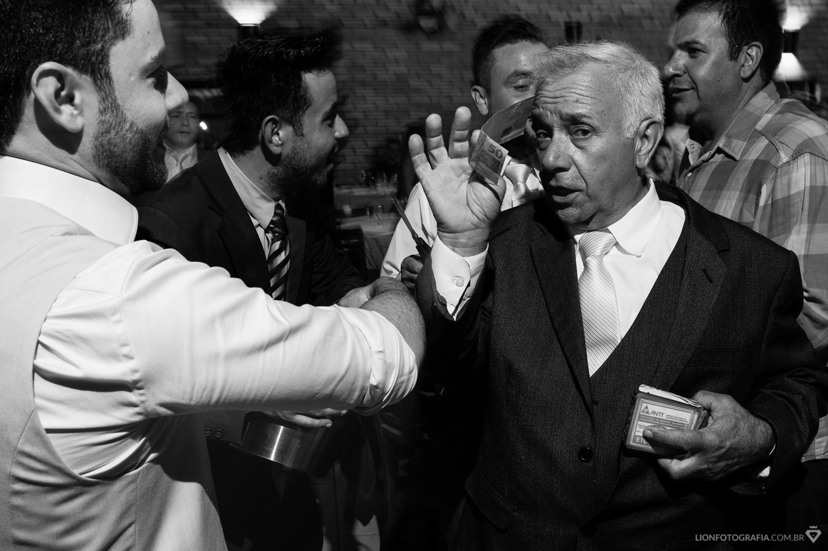 o pai do noivo colaborando com cinquenta reais na hora da gravata