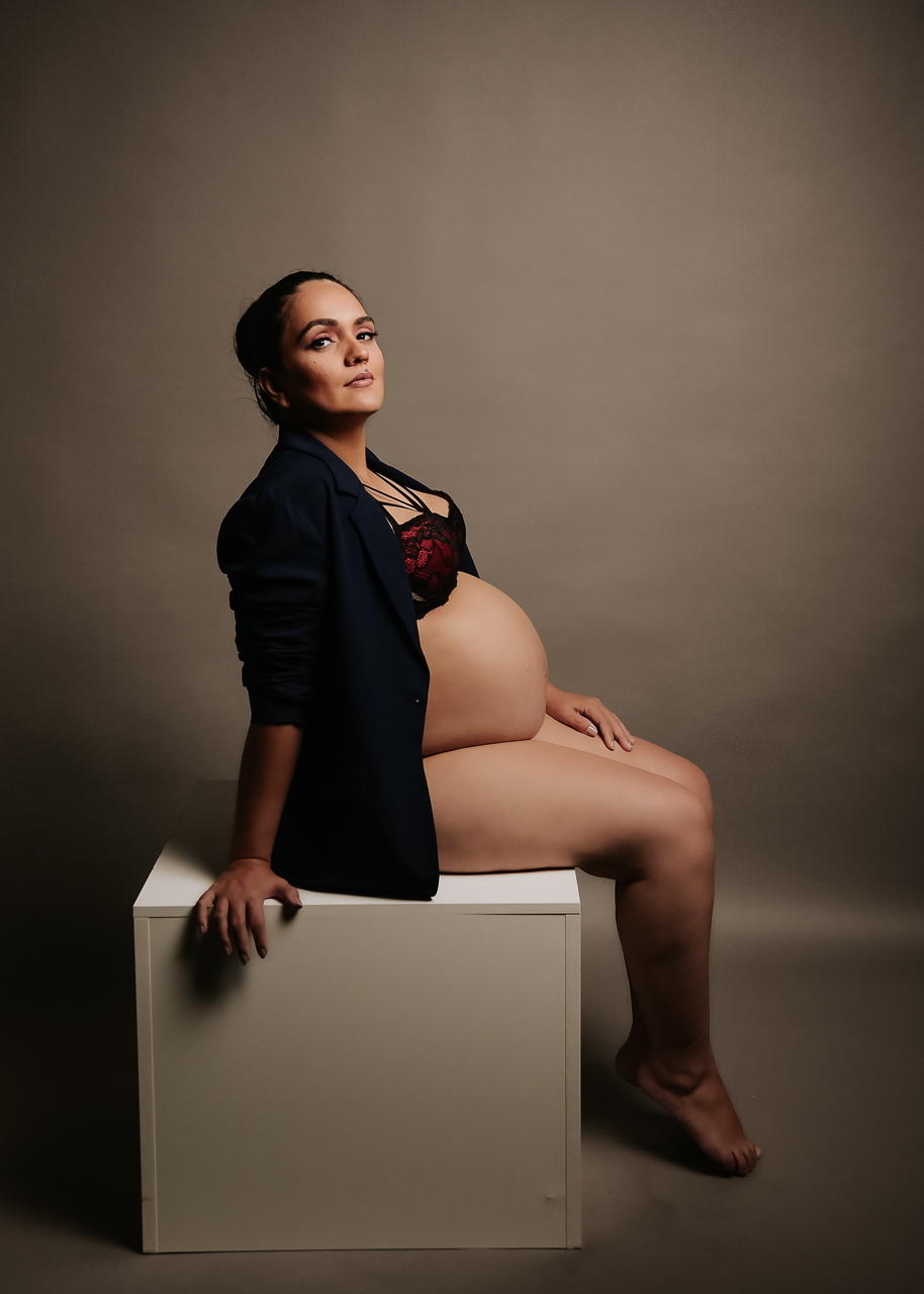 Foto de grávida com terninho e barriga à mostra.