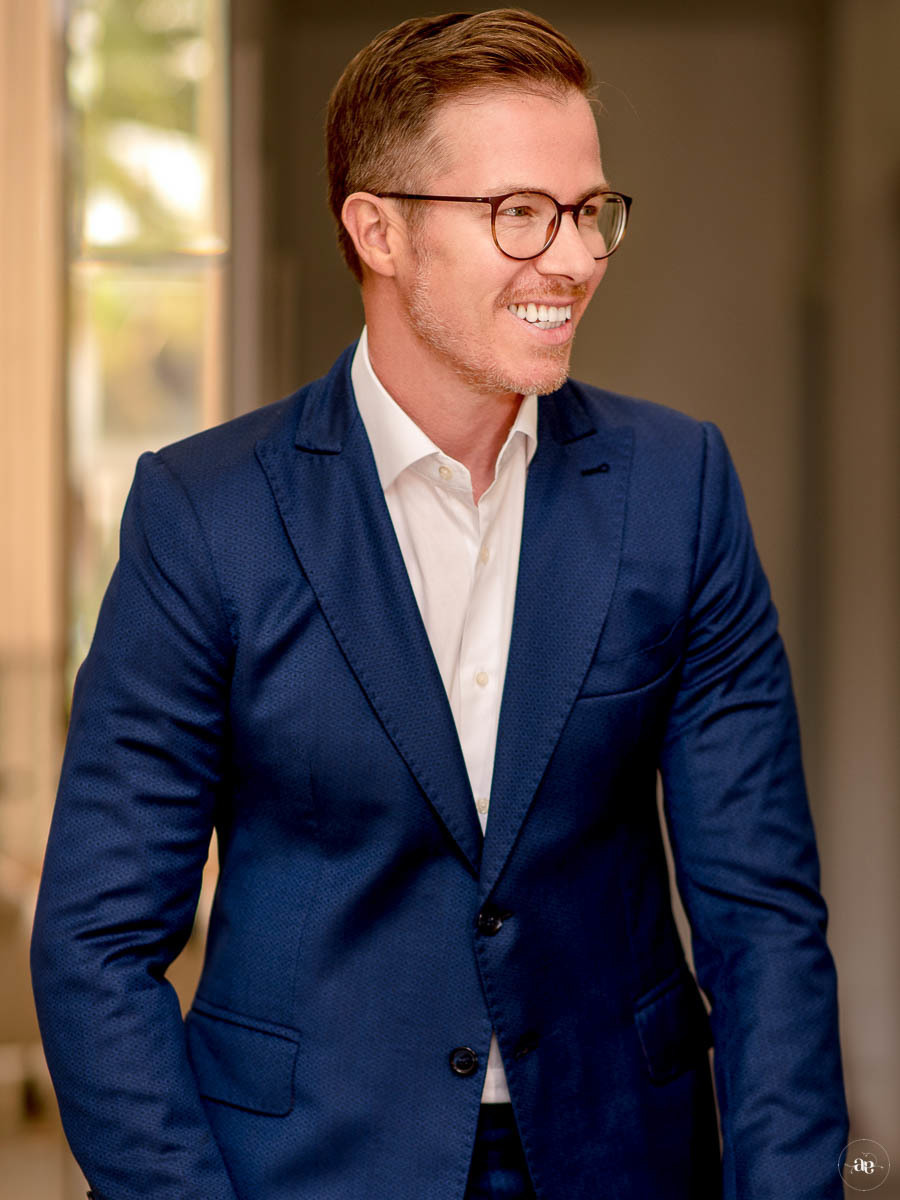 Retrato corporativo do Dr. André Tubino em pé, vestindo traje azul, com postura firme e composição que valoriza sua presença e autoridade profissional.