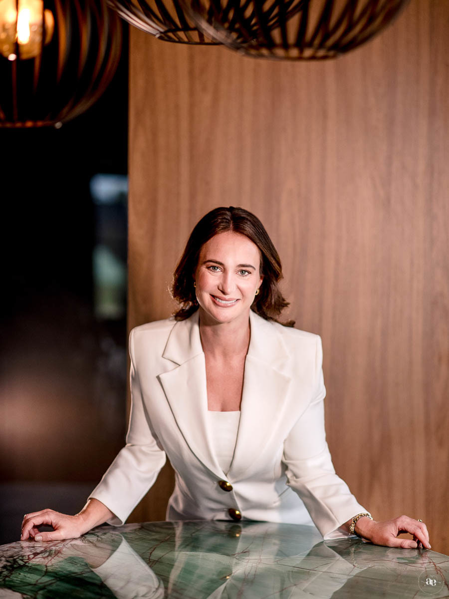Retrato corporativo da Dra. Kátia Blume em blazer branco, com composição sofisticada e iluminação suave, valorizando sua presença profissional na odontologia estética.