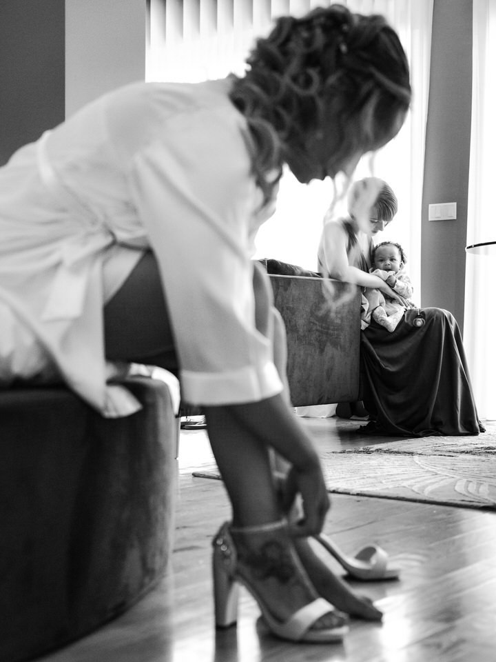 Noiva a ser arrumar com o filho ao fundo da imagem