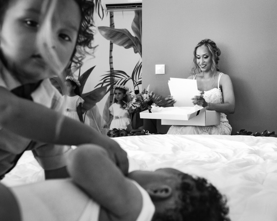 Crianças a brincar enquanto a noiva se prepara ao fundo do quarto