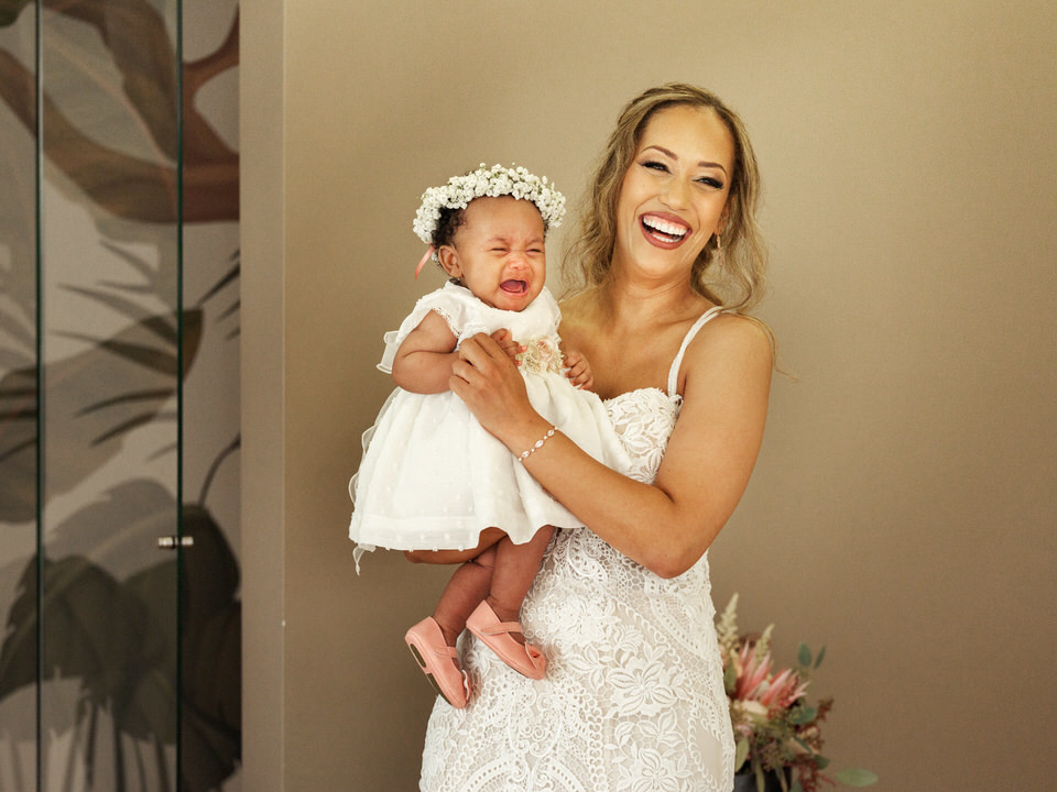 Noiva a sorrir ternamente enquanto segura um bebé