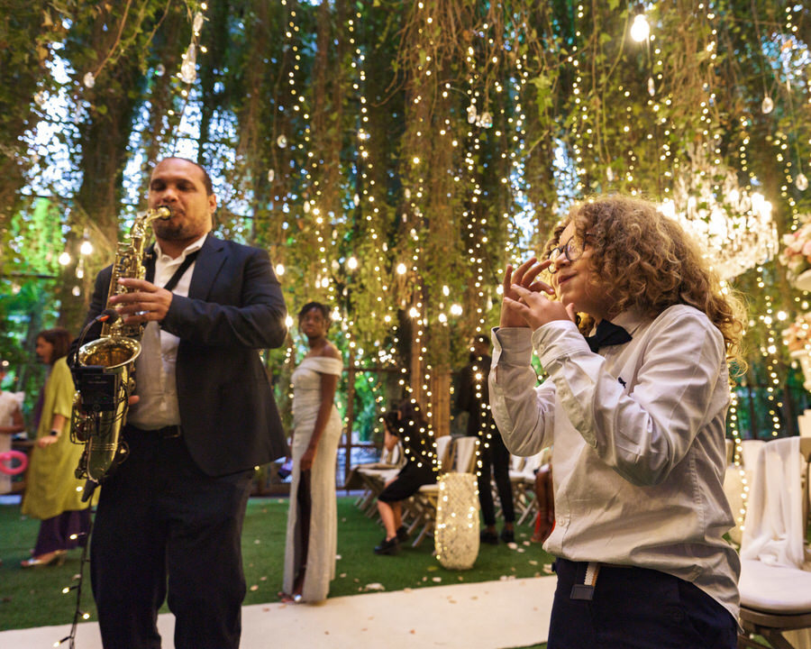 Músico a cantar sob folhagem natural durante a cerimónia