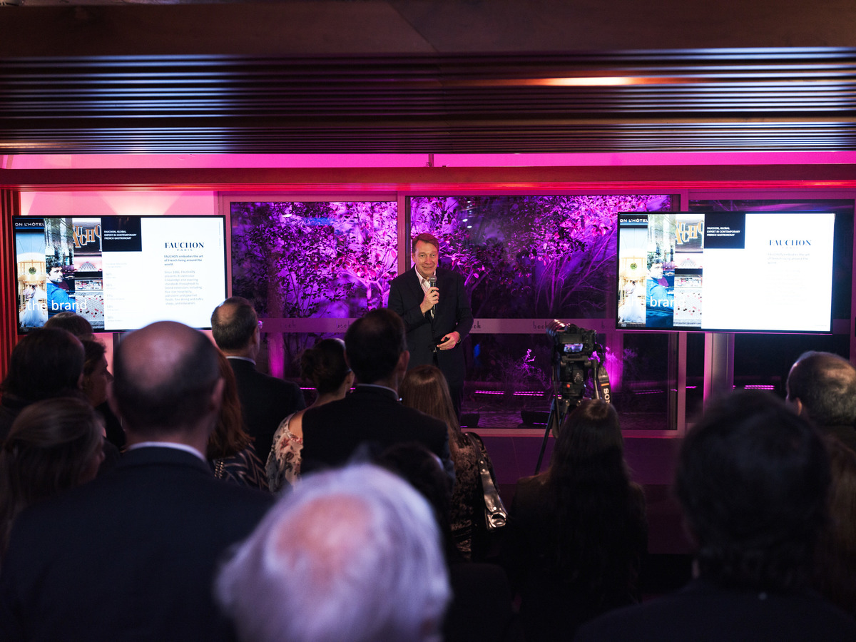 Foto ampla a partir do fundo da sala captando todos os convidados reunidos.