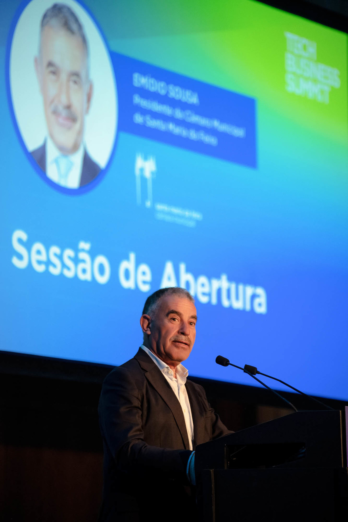 Foto do orador, Emidio Sousa, Presidente da Camara Municipal de Santa Maria da feira, a falar ao microfone com expressão confiante durante a apresentação.