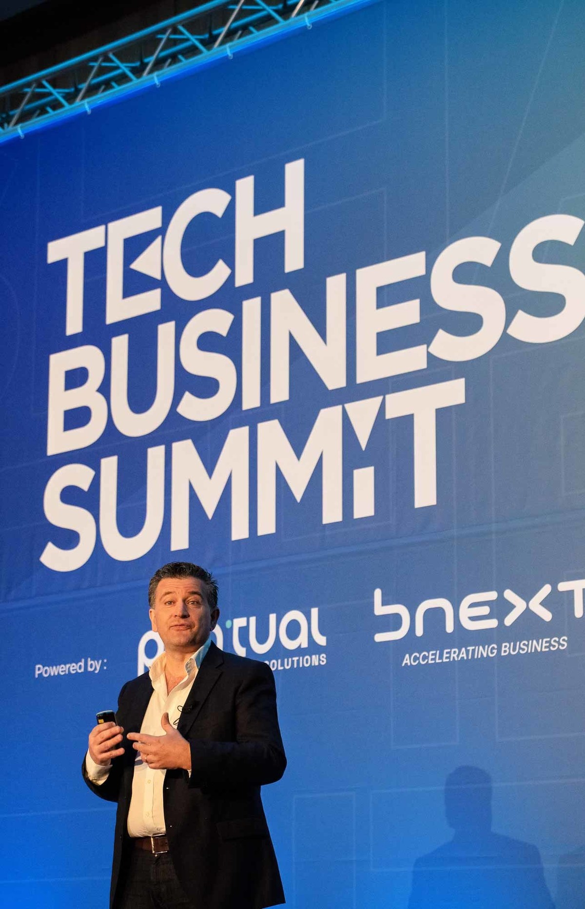 Imagem do orador António Teixeira.
CEO – PONTUAL IT Business SolutionsAntónio Teixeira
CEO – PONTUAL IT Business Solutions com ecrã dividido ao fundo com gráficos.