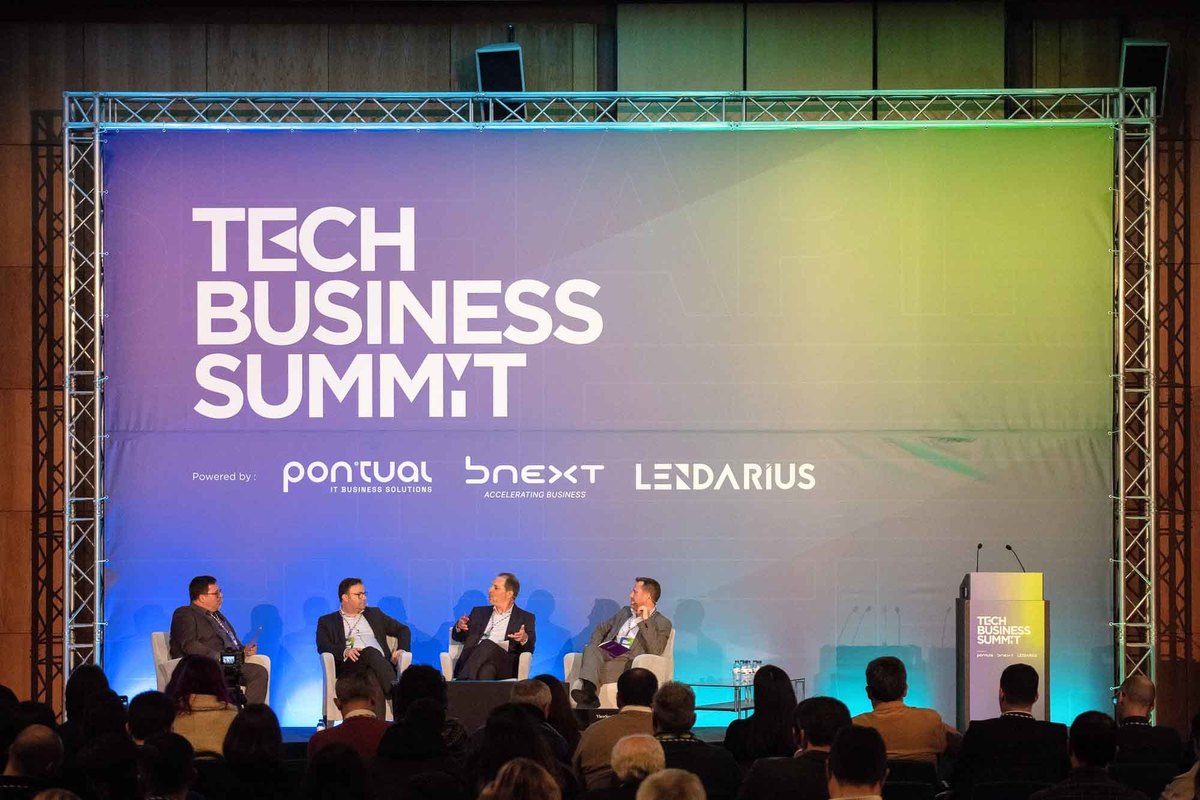 Vários oradores em cima do palco preparados para iniciar o painel.