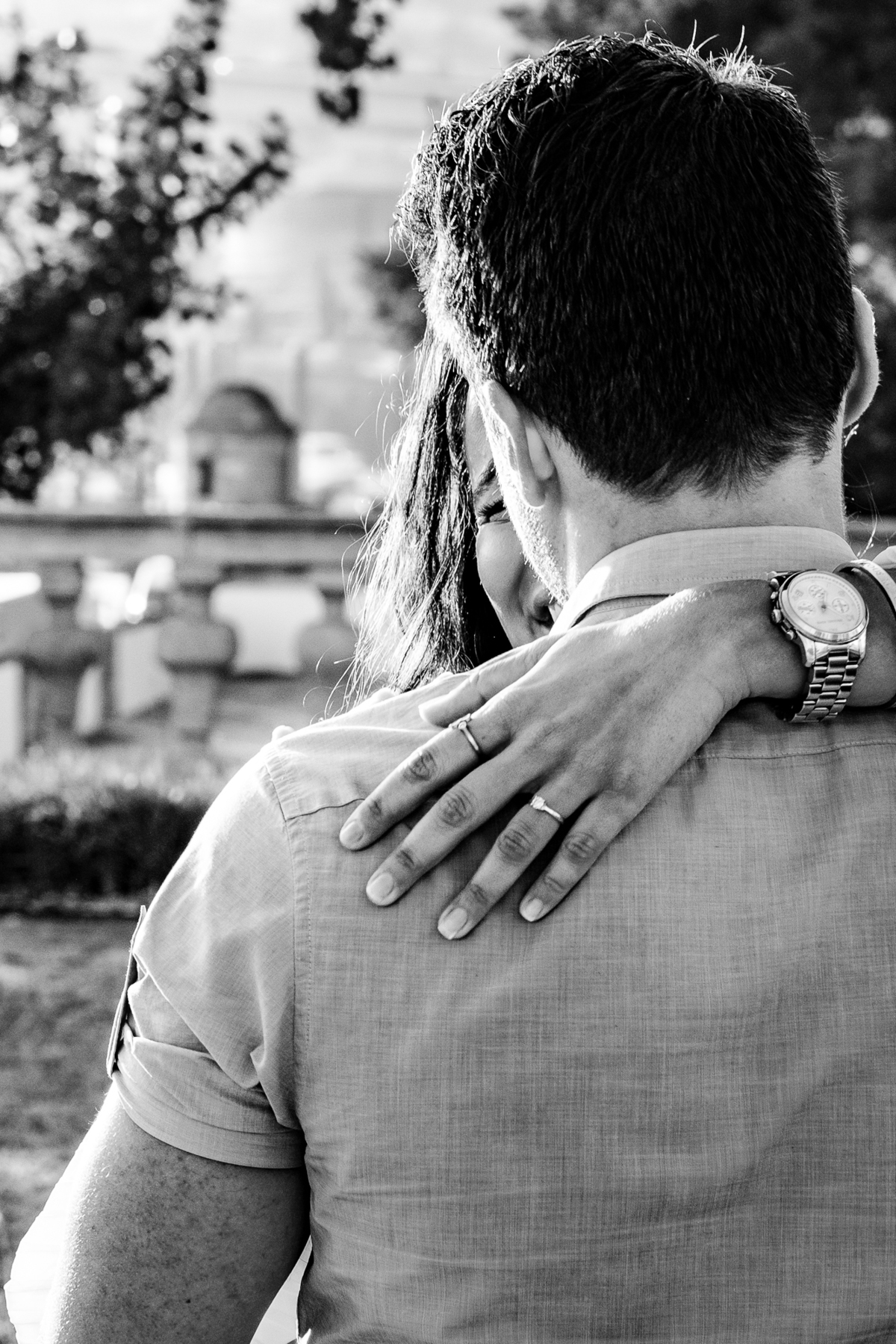 Close-uo da mao da noiva abraçada no noivo.