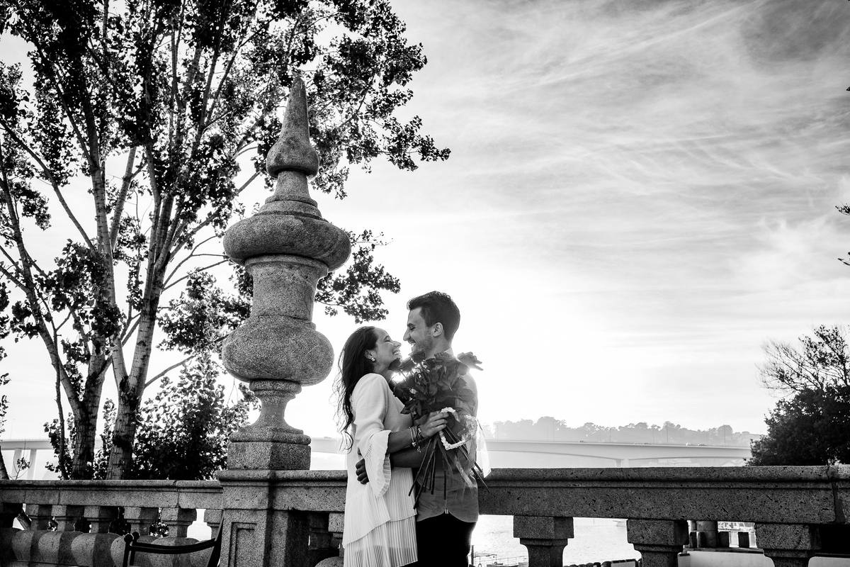 Fotografia a preto e branco de casal apaixonado a beijar-se, capturando um momento íntimo e romântico com estilo clássico e intemporal.