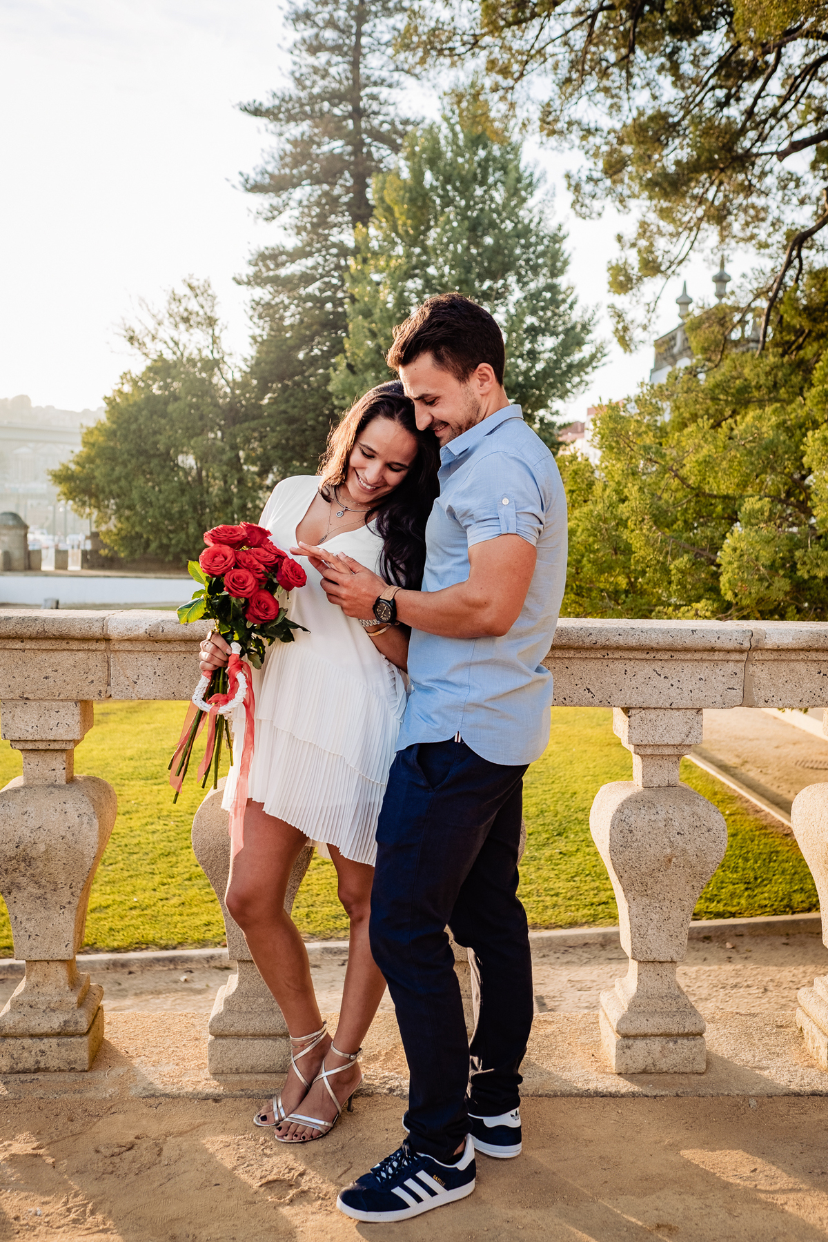 Casal de noivos abraçados com a luz dourada do sol a iluminar o seu rosto.