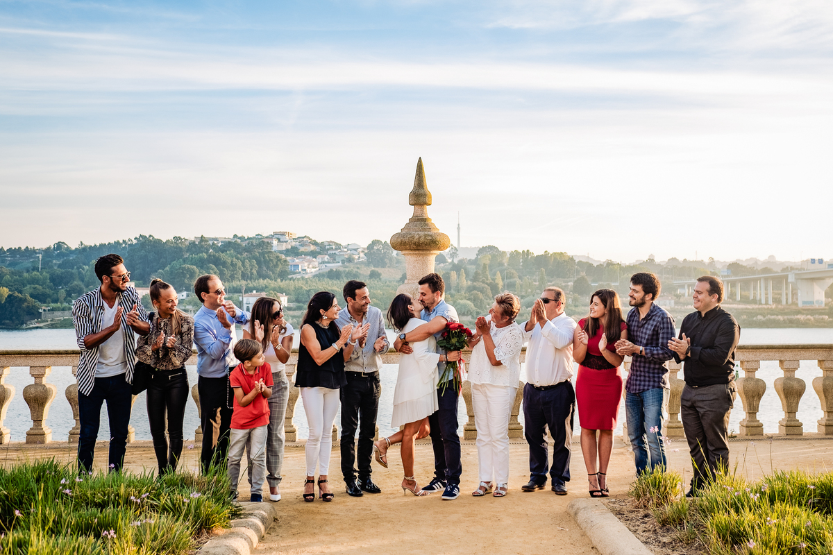 Foto dos noivos e convidados alinhados em linha reta com sorrisos radiantes a celebrar o anúncio do noivado