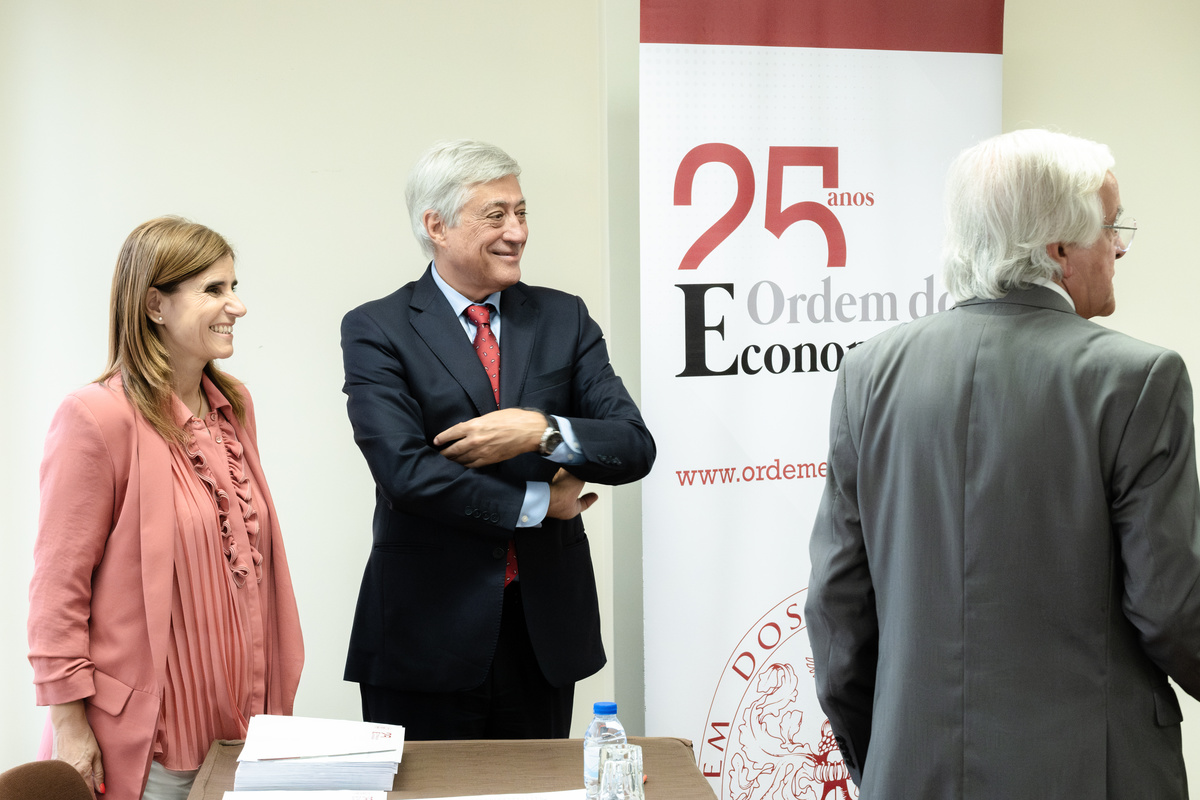 Duas pessoas em conversa próxima durante evento da Ordem dos Economistas