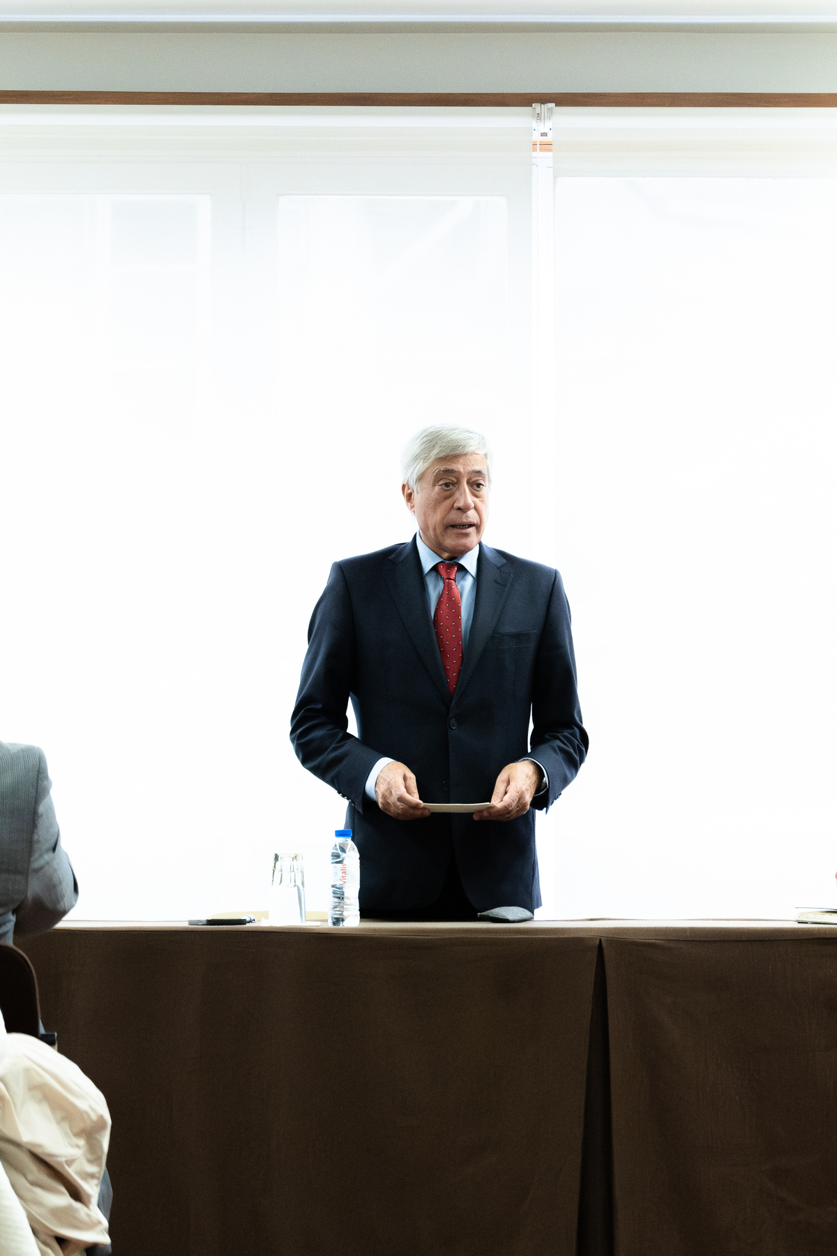 Homem a proferir discurso formal em sessão corporativa