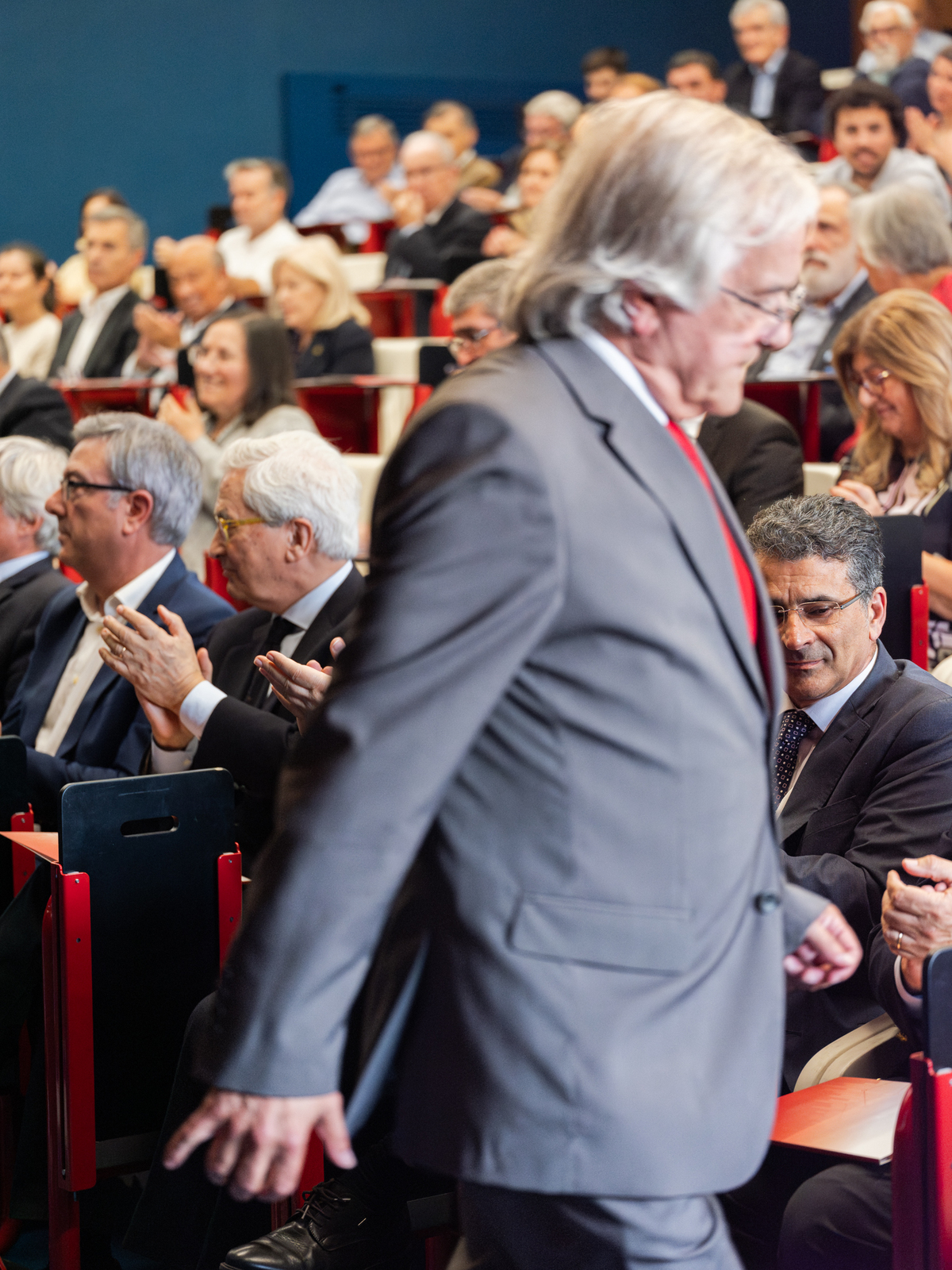 Plateia a aplaudir animadamente durante apresentação no evento corporativo.