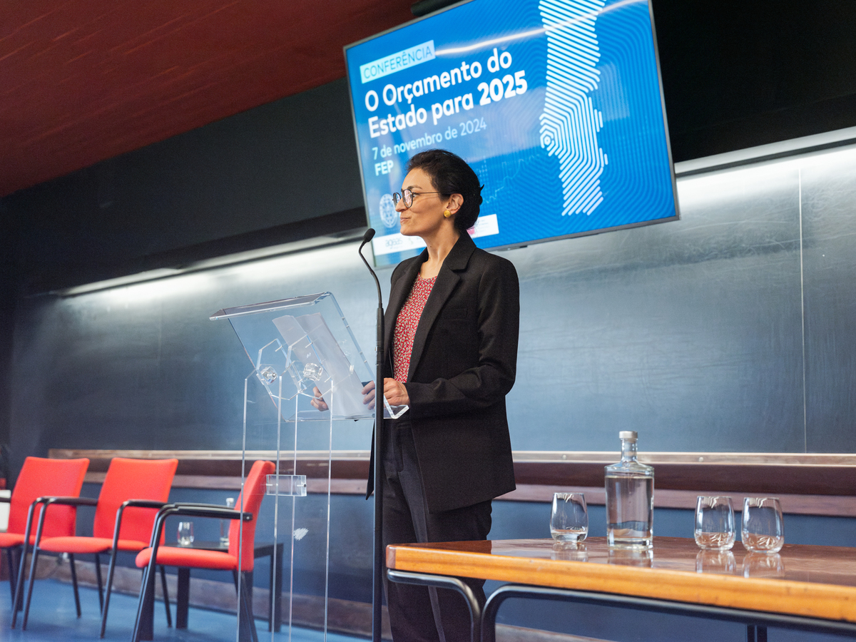 Palestrante a usar microfone enquanto destaca pontos importantes