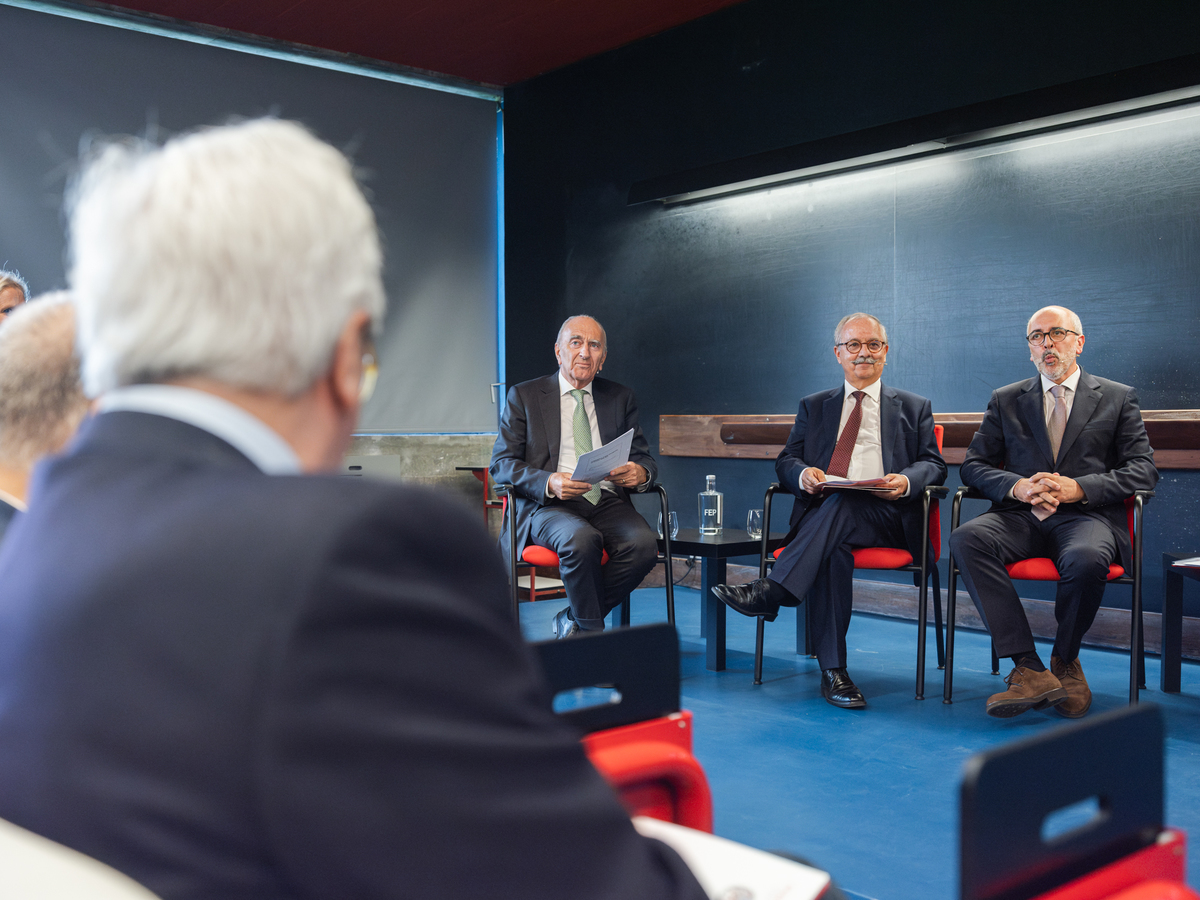 Fotografia de profissionais sentados a partilhar opiniões na plateia.