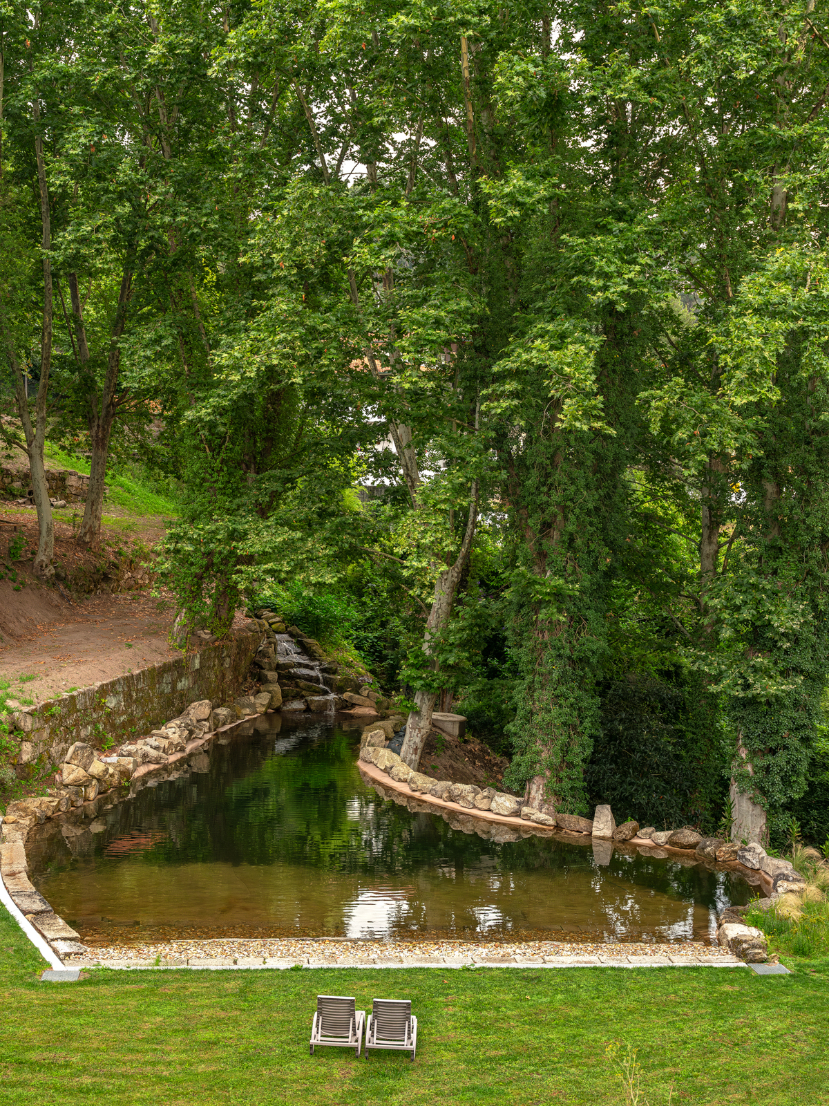 Jardins do hotel com trilhos pedonais entre árvores